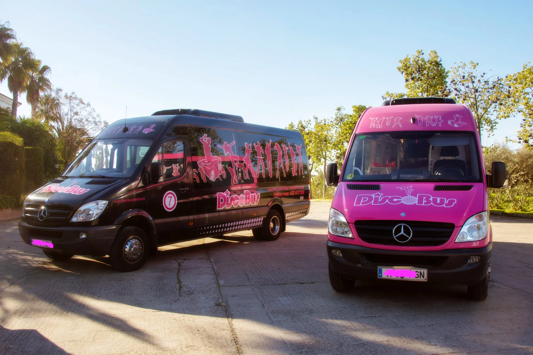 Dos limobuses de fiesta coloridos, decorados con luces brillantes y rodeados de un ambiente festivo.